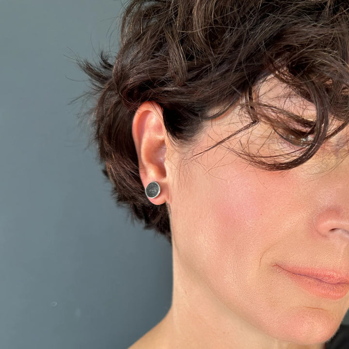 This picture depicts the stainless steel stud earrings on a female model.