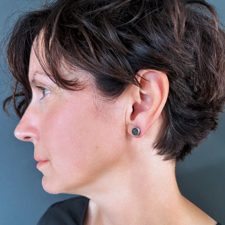 This photo depicts the stainless steel stud earrings on a female model.