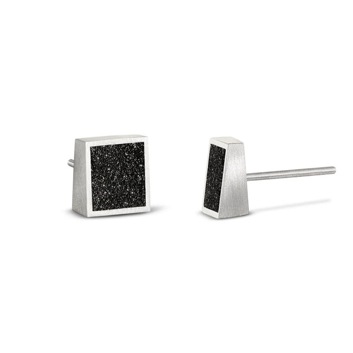 These stainless steel stud earrings are square in shape and feature a dark, shiny centerpiece made from concrete and diamond dust encased in a stainless steel border.