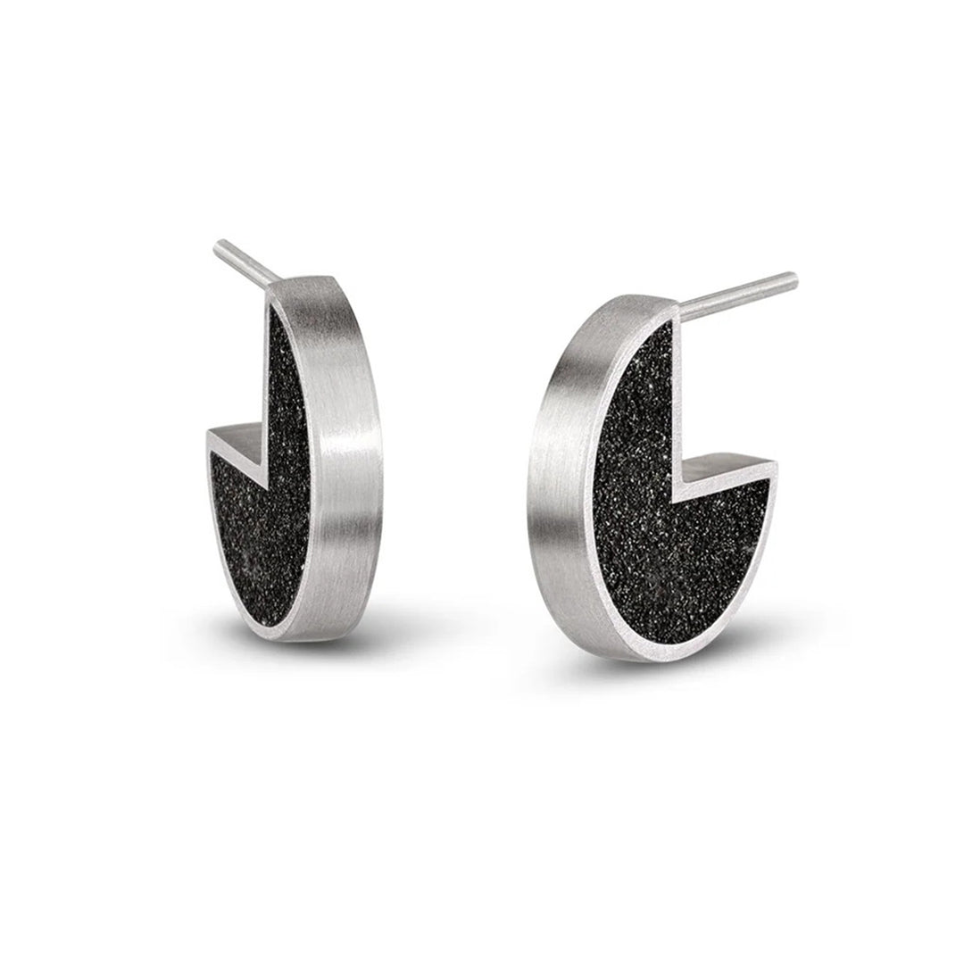 These stainless steel stud earrings are circular in shape with a quarter of the circle cut out to fit comfortably on the earlobe. The inside is dark and shiny with a stainless steel outline.