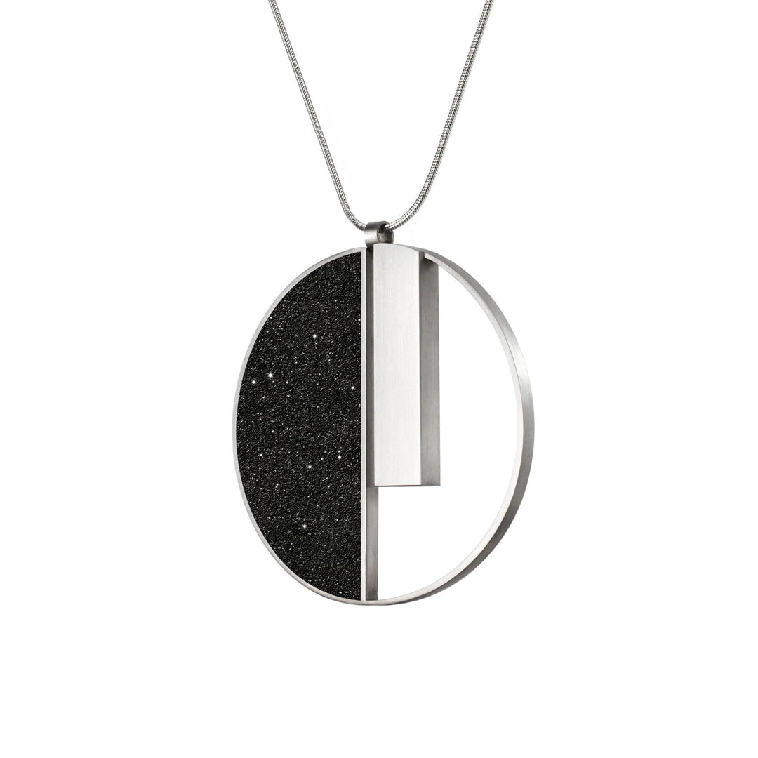 This stainless steel necklace is round in shape. The left side is black in colour with sparkles while the right side has been cut out except for a long, vertical bar hanging from the top.