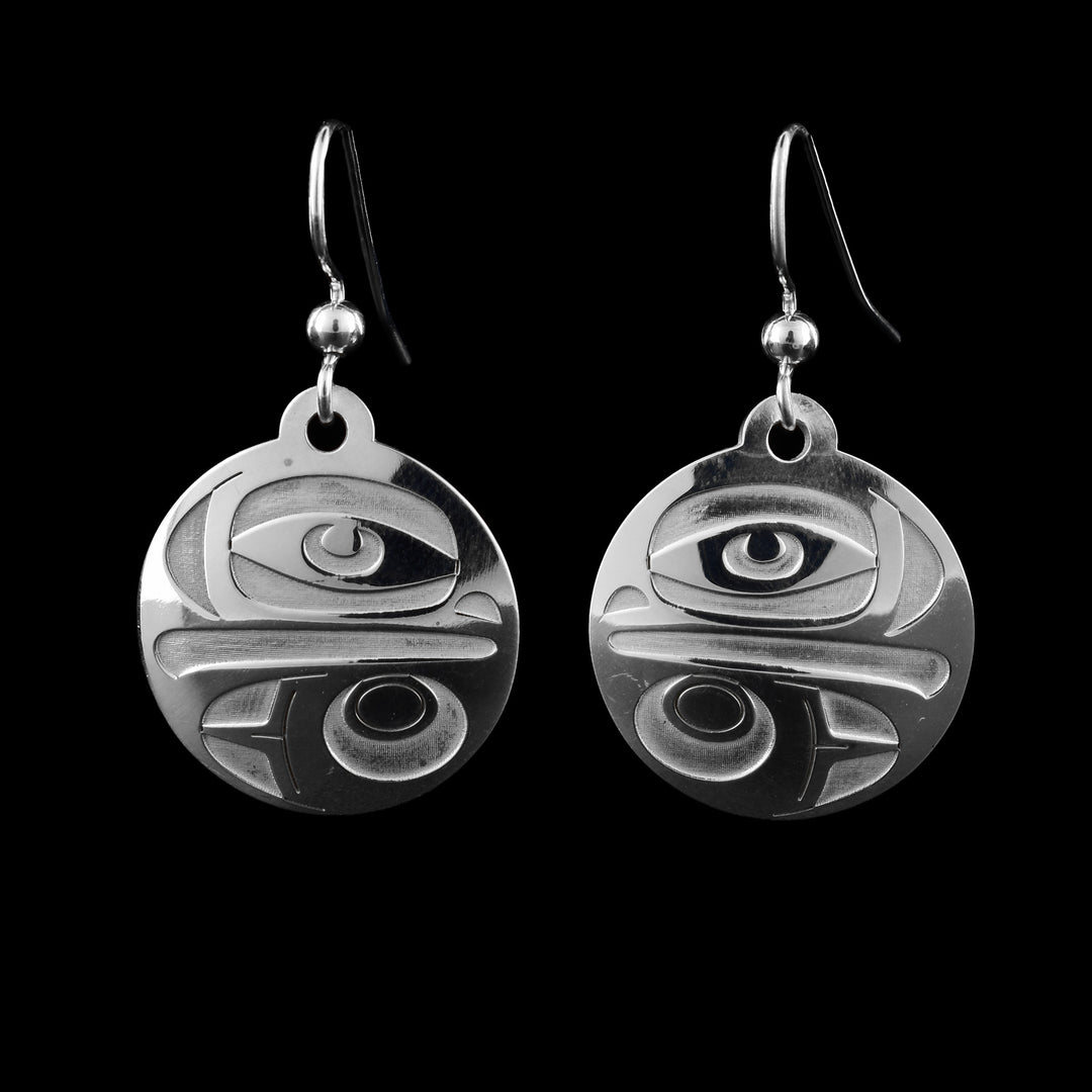 These sterling silver Eagle earrings have circle shaped hangs that dangle from hooks. A depiction of the Eagle legend is made on the hangs with its large eye and beak at the top half of them. Below, there is a design showing one of its wings.