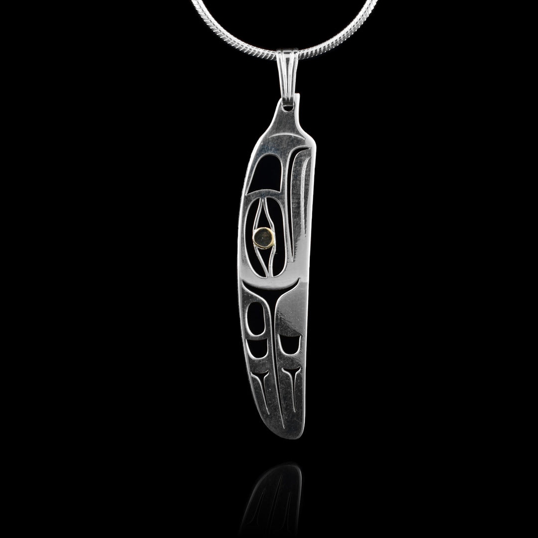 This Eagle feather pendant has been made from sterling silver and 14K gold. The pendant is mostly silver and is shaped like a feather. There are cutouts on the piece depicting the Eagle legend with its head at the top facing up and a feather, wing- like design behind the head. The eye is done in gold.