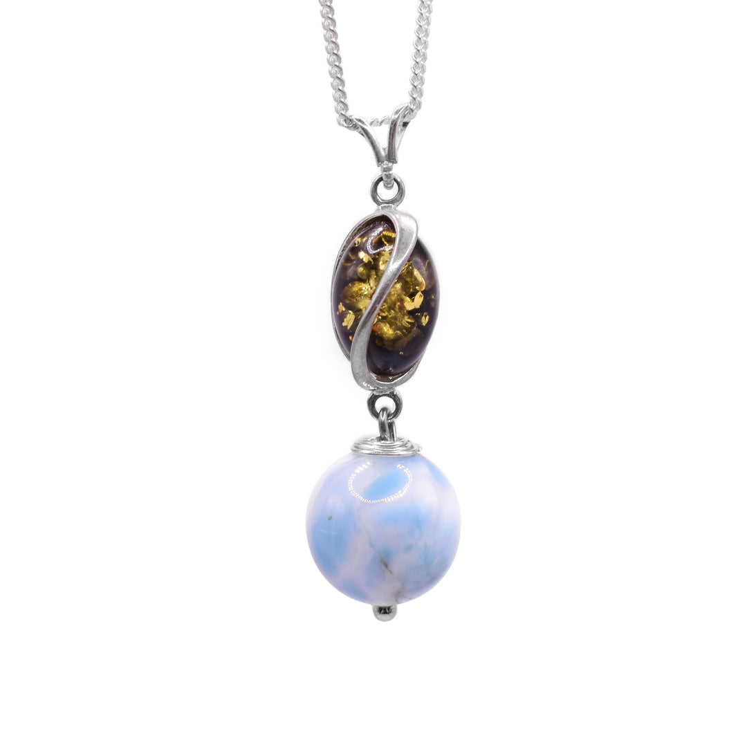 This larimarl drop pendant has a sterling silver charm with deep, spiral ridges in it. In these ridges, there are amber pieces. Below the dangling charm, there is a large, sphere shaped larimar bead and the piece is held together using sterling silver.