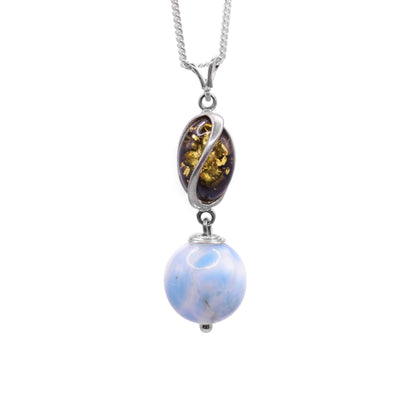 This larimarl drop pendant has a sterling silver charm with deep, spiral ridges in it. In these ridges, there are amber pieces. Below the dangling charm, there is a large, sphere shaped larimar bead and the piece is held together using sterling silver.