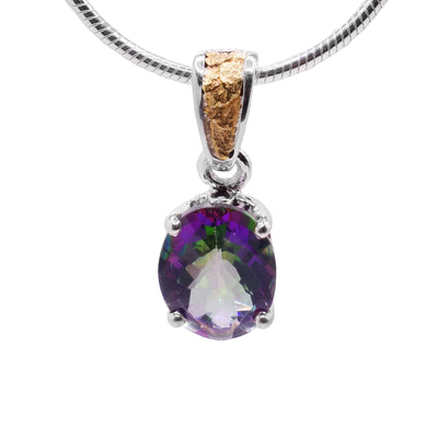 This blue topaz gold pendant is in the shape of an oval and has the colours green, purple, blue, and pink. The topaz is held in place by a sterling silver claw setting. The attached bail has 22k yellow gold nuggets on the front.