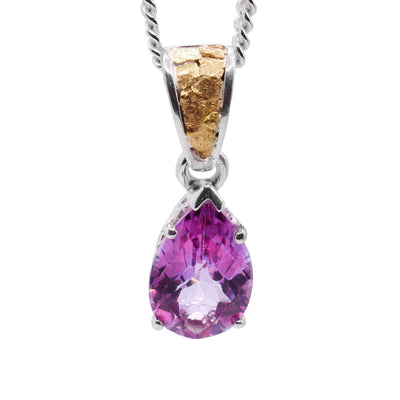 This pink topaz pendant has a teardrop shaped gem made from pink topaz. The gem dangles from a large, sterling silver bail with 22K nuggets on the surface of it.