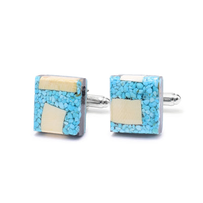 These turquoise cufflinks have a square shaped and are made by encasing small pieces of turquoise and chunks of mammoth ivory in resin. The cufflinks are set on sterling silver backs.
