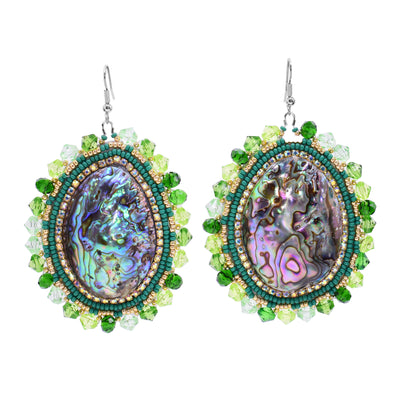 These dangling beaded earrings have large, oval shaped abalone hangs with chromatic colours on the surface of them. There are different coloured green beads and gold highlight beads woven into a pattern around the outside of the piece. There are small beads lining the circumference of the abalone and larger beads on the very outside of the hangs.