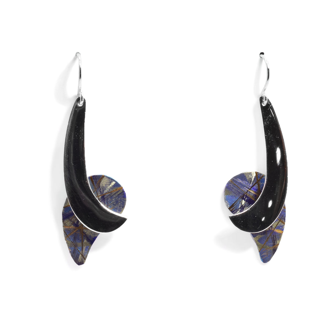 These unique drop earrings have long, swooping pieces of sterling silver dangling from the hooks. There is a large teardrop shaped piece of anodized titanium at the bottom of each earrings with colorful designs across its surface. the Titanium is purple with orange, yellow and blue highlights on it.