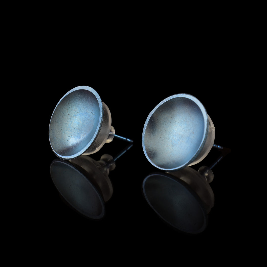 These titanium earrings studs are circle shaped and have a deep concave. The studs have a shiny blue colour on their surface