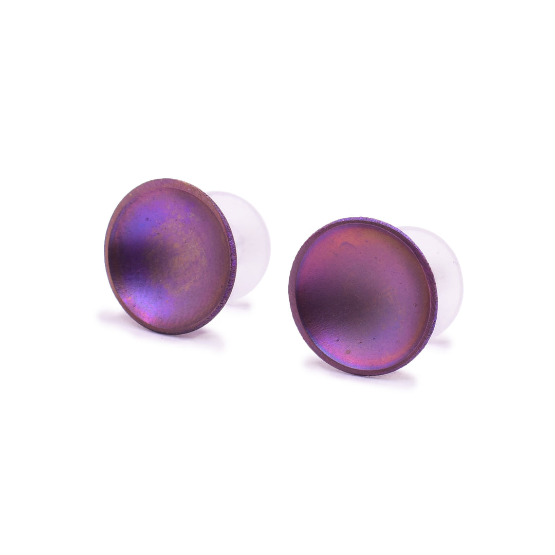 These titanium earrings studs are circle shaped and have a deep concave. The studs have a shiny pink, gold and purple colour on their surface