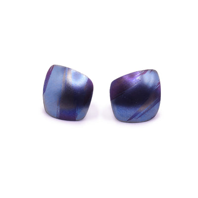 These small colourful titanium earrings are convex and have an uneven, square shape. There are splashes of pink, purple and blue with paint brush designs made across the surface of the studs.
