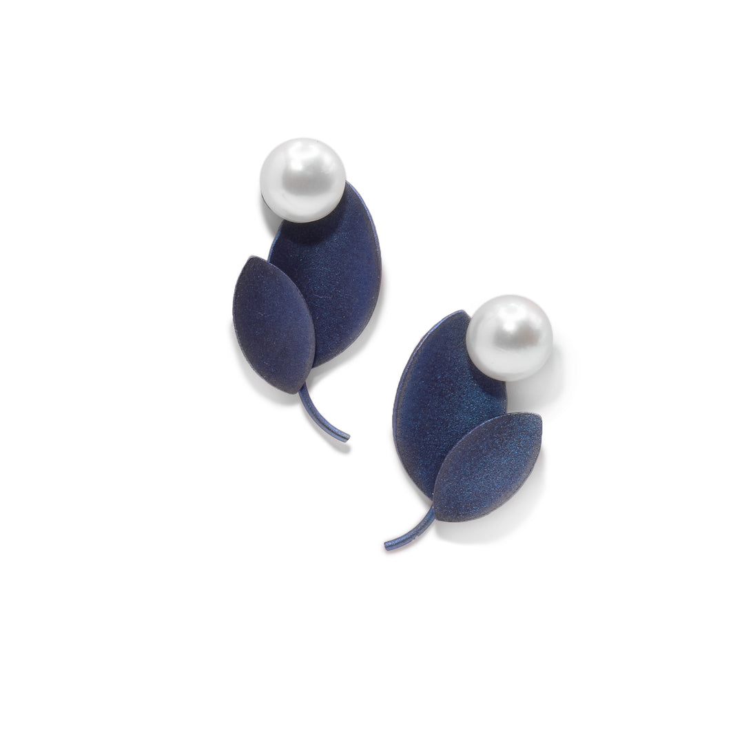 These leaf stud earrings are made from blue titanium and each one is shaped like two leaves. There are white, freshwater pearls at the top of the leaves on each stud.