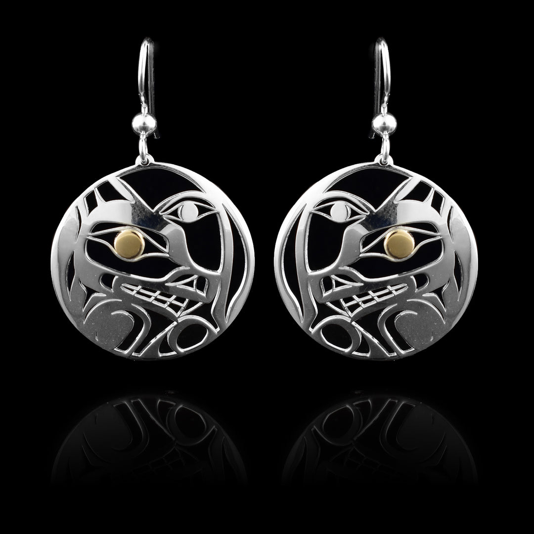 These Wolf Moon earrings have circle shaped hangs made from sterling silver and with cutout designs depicting the Wolf and the Moon legends. There are cutouts designing the head of the Wolf in a side profile and its eye is done in 14K gold. Beside the Wolf, half of the Moon is shown with its eye visible.