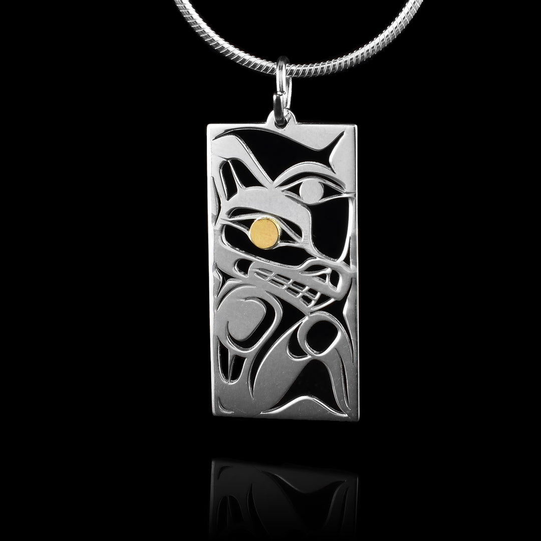 This Wolf and Moon Pendant has a rectangle shape and is made from sterling silver. There are cutouts designing the head of the Wolf in a side profile and its eye is done in 14K gold. Beside the Wolf, half of the Moon is shown with its eye visible.