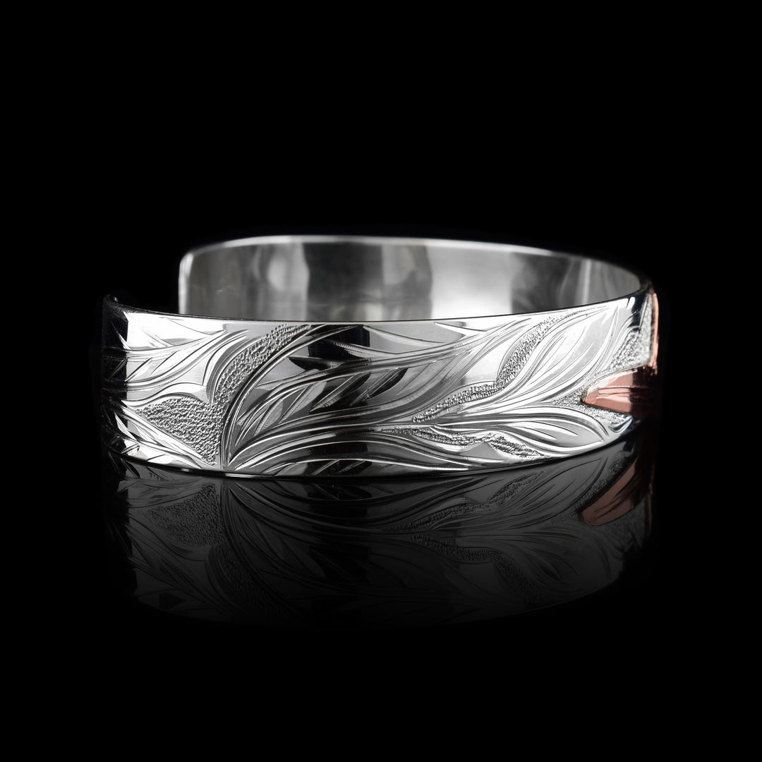 This sterling silver copper bracelet has a single band with a gap in the back. The head of the Hummingbird is done at a side profile using copper and there is a wing designs carved behind it on the band. On the other side there are floral design and its beak is reaching between two flower petals.