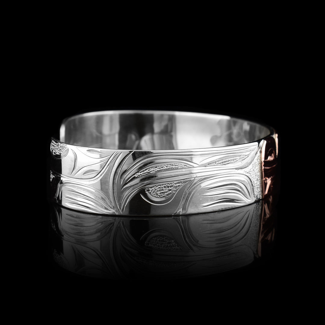 This sterling silver copper bracelet has a single band with a gap in the back and the head of the Wolf is depicted in the center of it. The head is done in copper and at a side profile. On both sides of the band, there are carvings showing the body of the legend with its paws, claws and tail detailed in a side profile.