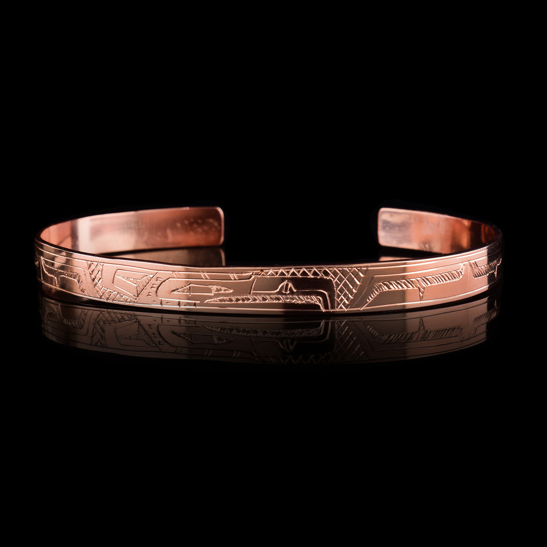 This Eagle bracelet has a single, thin band that is made form copper and has a gap in the back. The head of the Eagle is in the center of the band and is depicted at a side profile. The legend is depicted across the rest of the band.