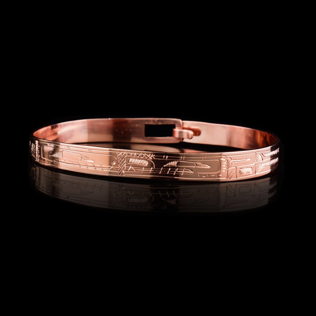This Orca Bear bracelet bangle has a thin band made from copper and has a clasp in the back. Depictions of the legends are carved into the band at a side profile and their faces meet in the center of the piece. 