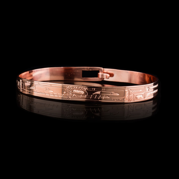 This Orca Bear bracelet bangle has a thin band made from copper and has a clasp in the back. Depictions of the legends are carved into the band at a side profile and their faces meet in the center of the piece. 