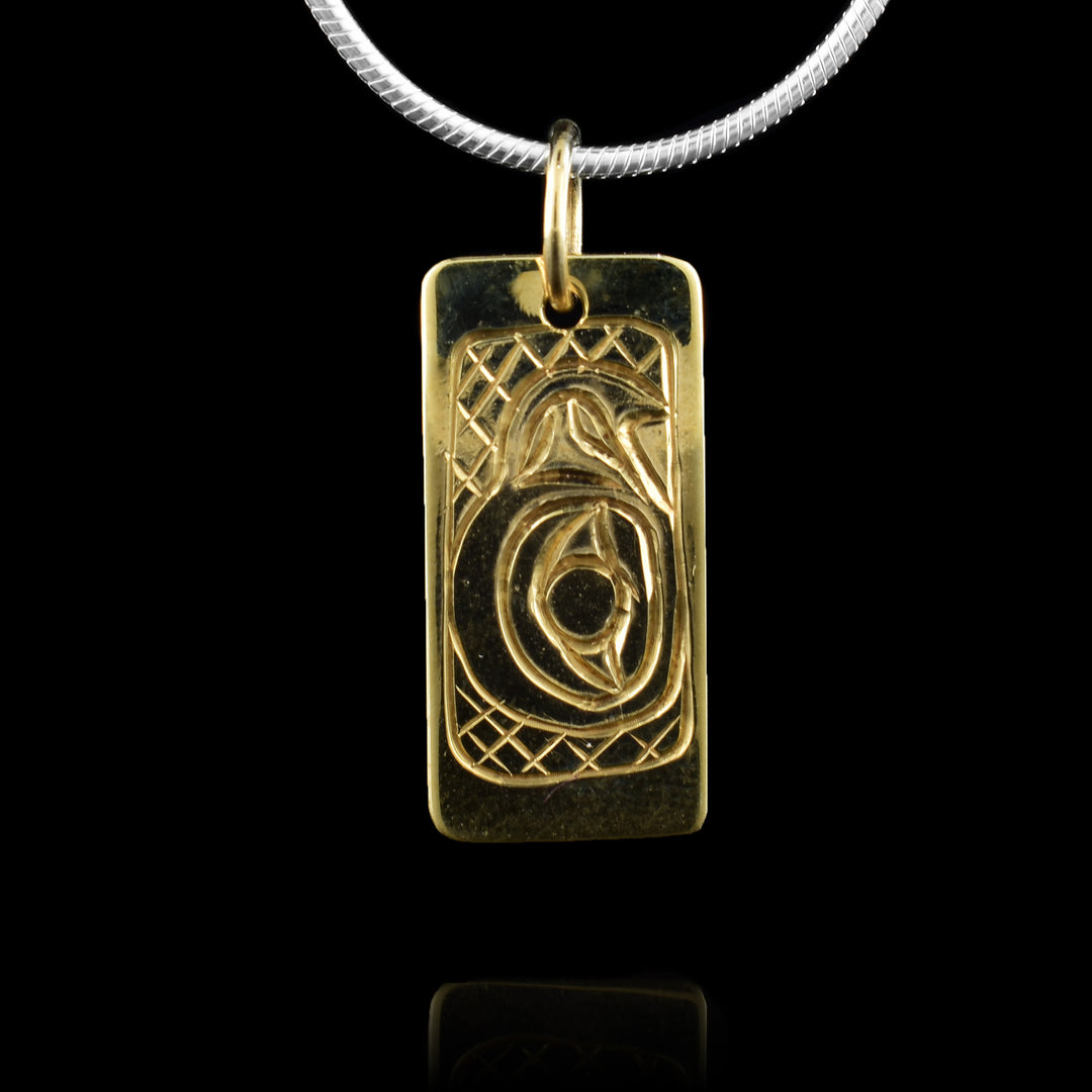 This 10K gold Eagle pendant has a small, rectangle shape with a depiction of the head of the Eagle carved into it at a side profile. The beak is facing up and its eye is very large with cross hatching designs in the background of the scene.