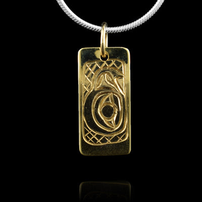 This 10K gold Eagle pendant has a small, rectangle shape with a depiction of the head of the Eagle carved into it at a side profile. The beak is facing up and its eye is very large with cross hatching designs in the background of the scene.