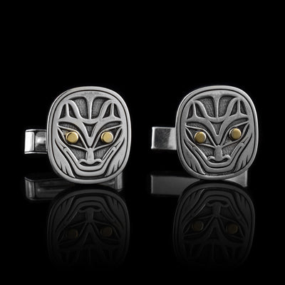 These cufflinks gold and silver are made from sterling silver and have wide, oval shapes. There is a depiction of the face of the Wolf cast into the surface of them. Its ears, two eyes, nose and mouth are detailed with its eyes being done in 14K gold.