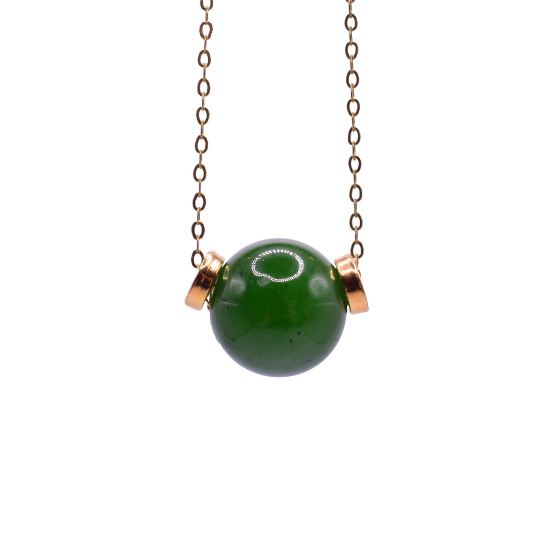 This jade bead pendant necklace has a sphere shaped pendant with a small, wide gold filled hoop on both sides of it.