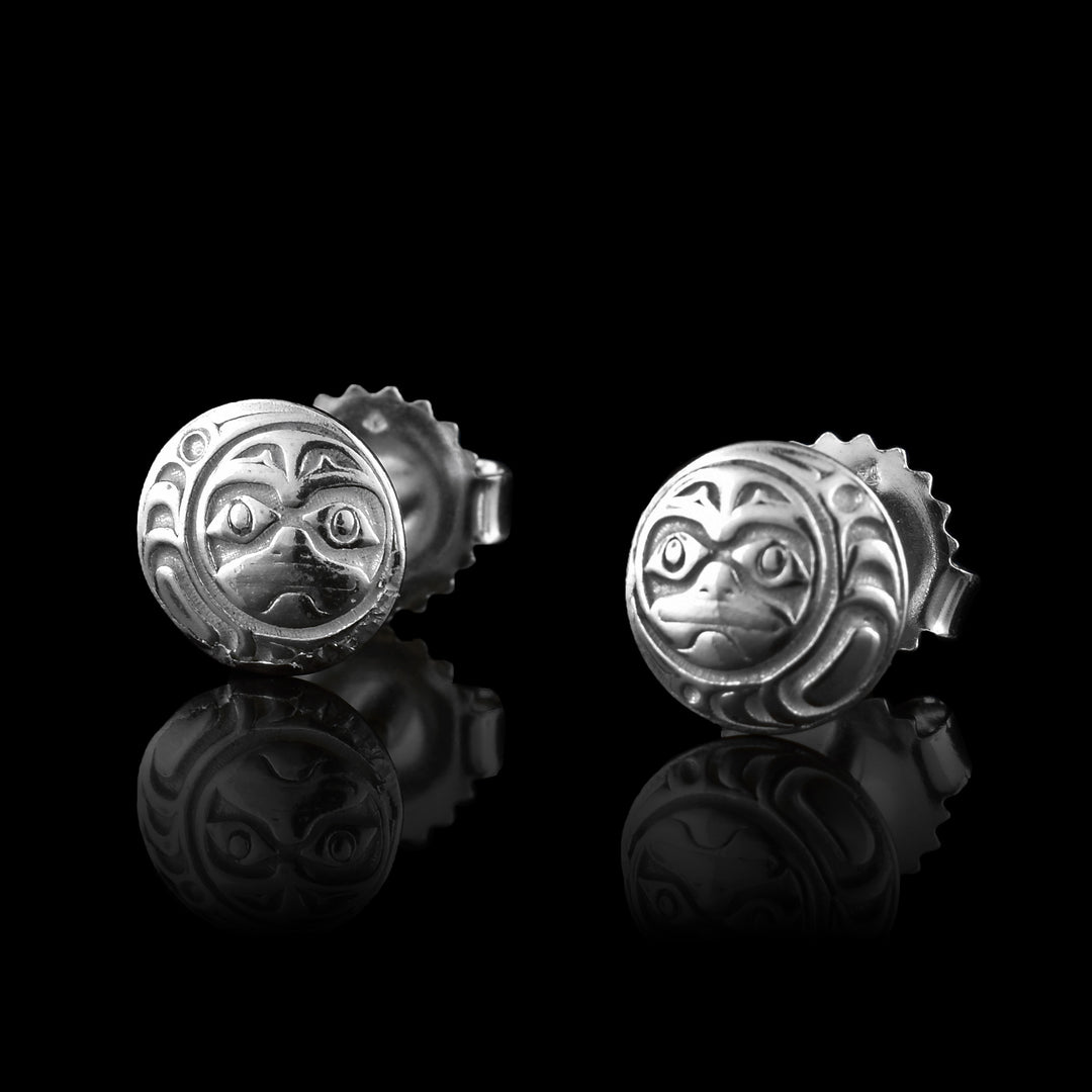 These Moon stud earrings are small and circle shaped and made from sterling silver. There are depictions of the face of the Moon cast into the studs.
