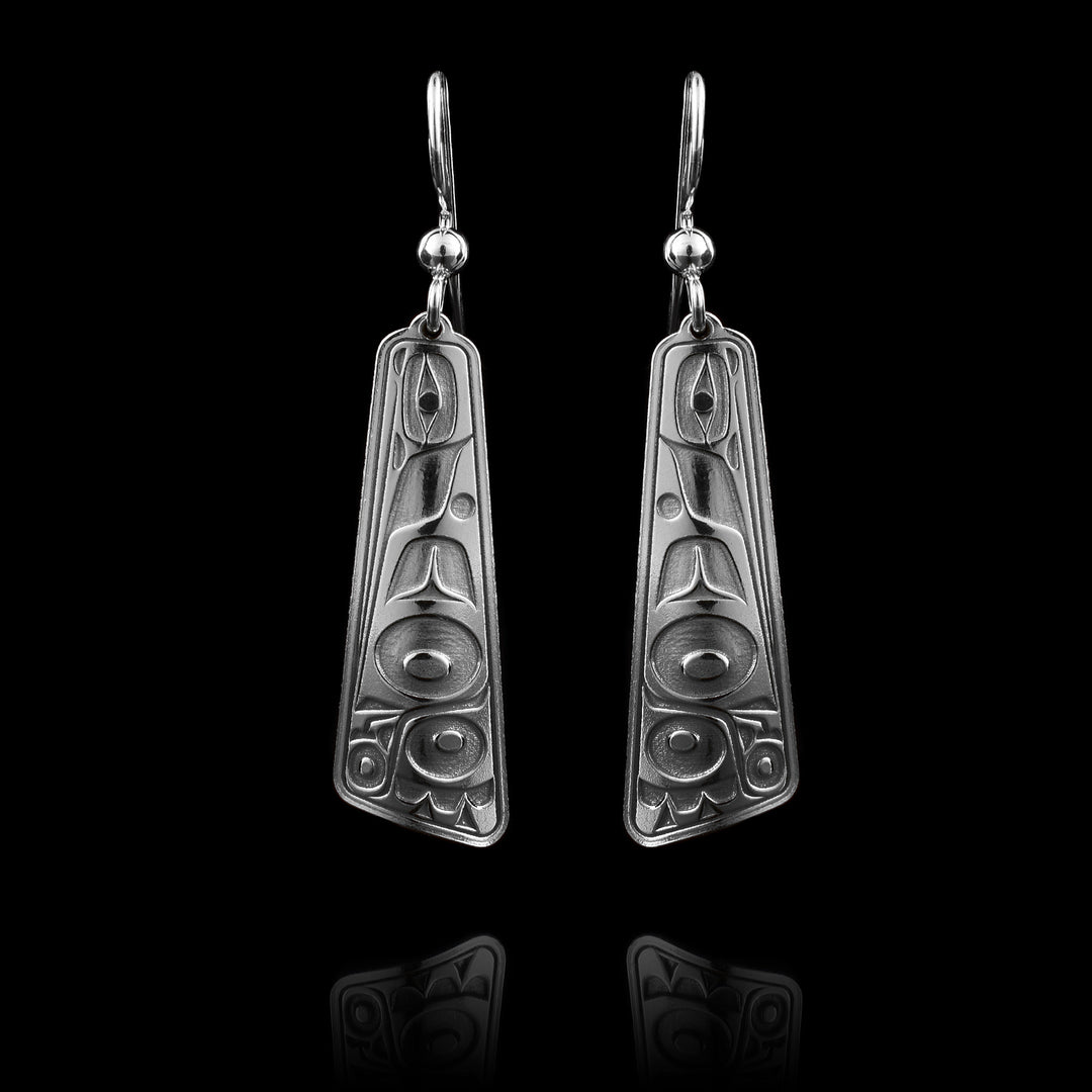 These dangle drop earrings silver have sterling silver hangs that taper out at the end and are rectangular. There is an abstract depiction of the Hummingbird cast into the hangs at a side profile. The head of the Hummingbird has its beak facing down and there is a large wing design made across the surface of the hangs.