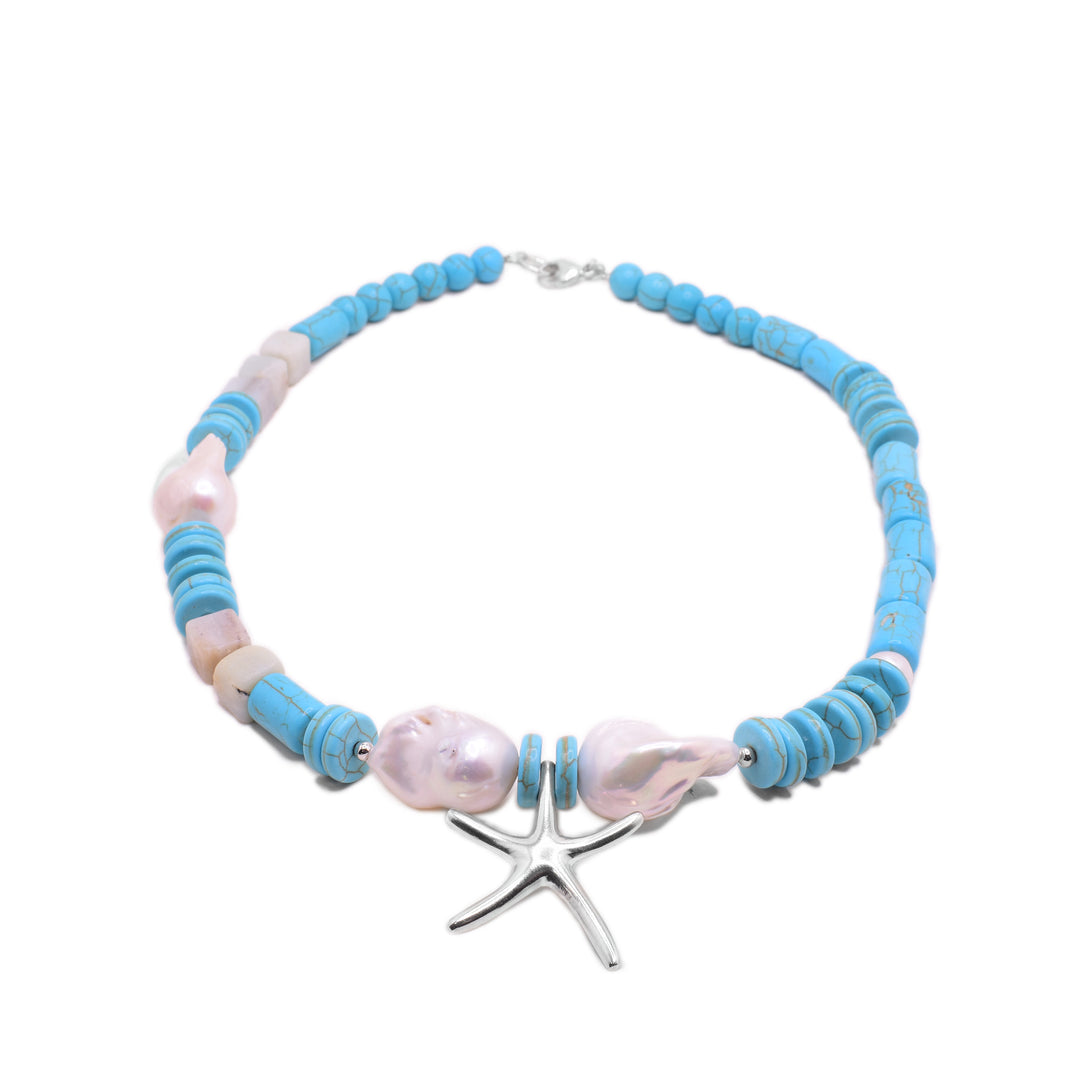 This starfish necklace has round, flat turquoise beads that run around it. There is a thin, sterling silver starfish pendant with large, baroque pearls to either side of it. There are a few small pearls highlighted around it.