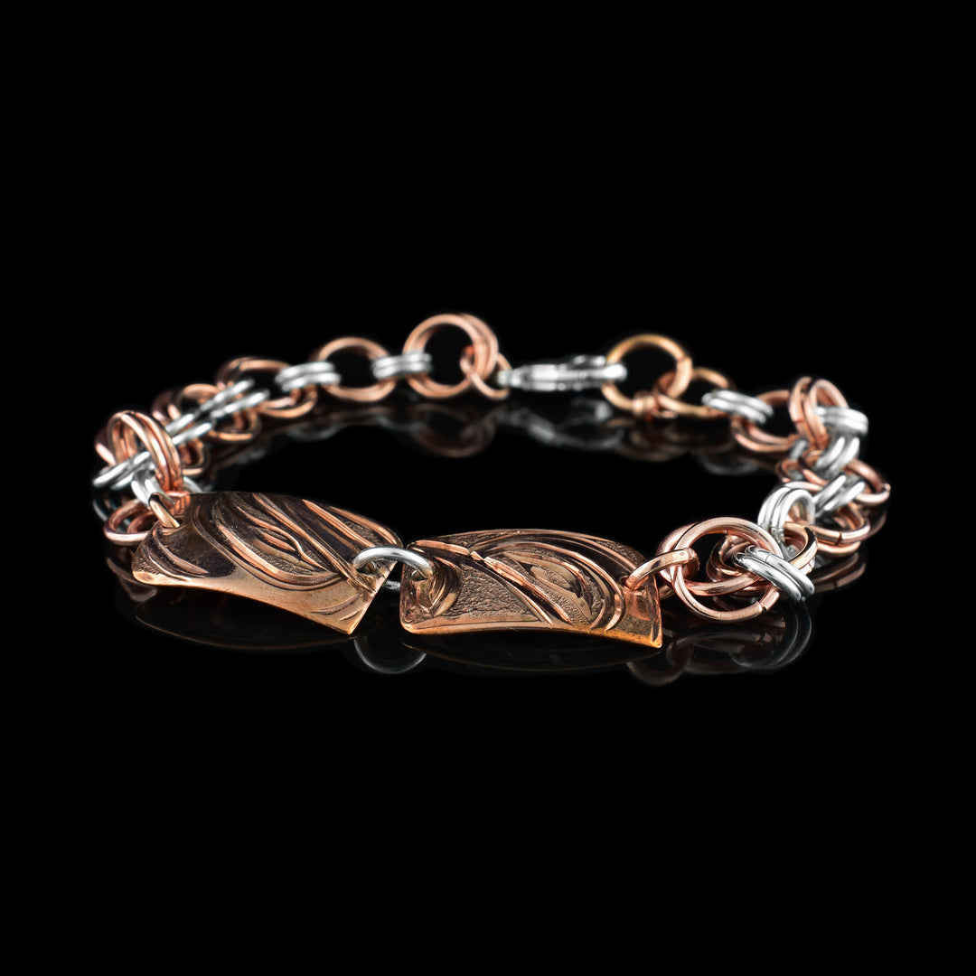 This sterling silver copper chain bracelet has double copper links hooped through double silver links to make the chain. There are two, rectangle and copper plates at the top with the head of the Hummingbird and Orca carved into them.