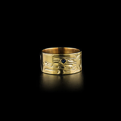 Front of ring. Wide band. Side-view of eagle’s face with a sapphire in eye. Design done in ovoids and lines.