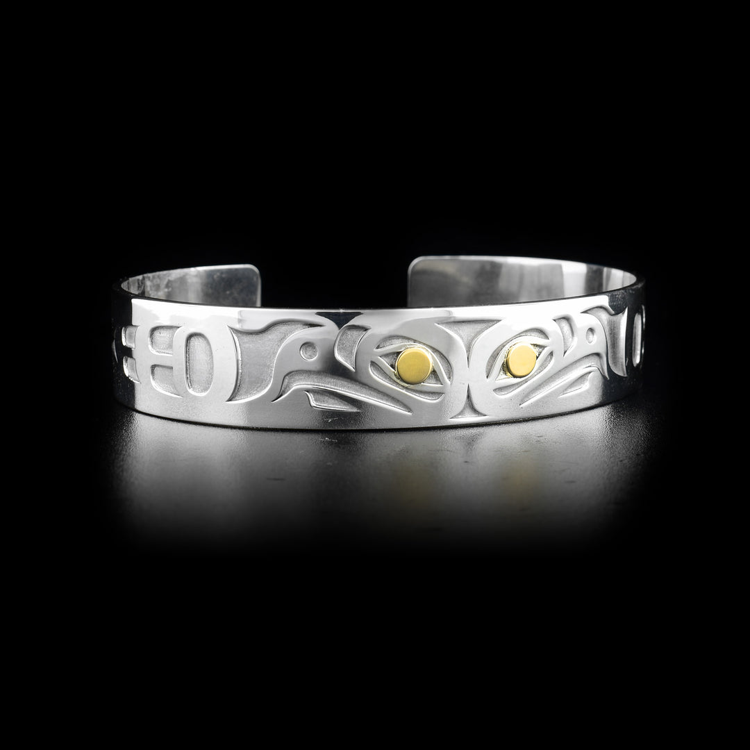 Cuff bracelet featuring two eagles back-to-back with 14K gold in eyes. Laser-carved design by Tahltan artist Grant Pauls.