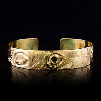 This Hummingbird gold cuff bracelet is made from solid 14K gold and has a single band with a gap in the back. There is a depiction of the Hummingbird and flowers that have been intricately carved into the surface of the band.