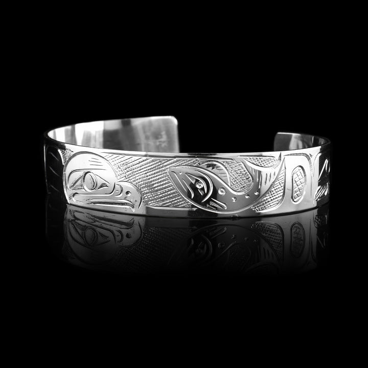 1/2" Sterling Silver Salmon and Eagle Cuff Bracelet  - Made with sterling silver the Coast Salish artist Graham Henry has hand carved the legend of the Eagle and Salmon are carved on the surface of the bracelet.