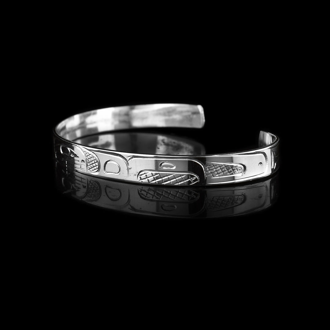 This quarter inch wide sterling silver cuff bracelet is hand carved with the indigenous legend of the Orca. 