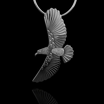 This flying Eagle pendant is made form sterling silver and is shaped like an eagle in flight. The wings extend vertically and there are feather details on the wings and tail. There are details included on the head of the eagle.