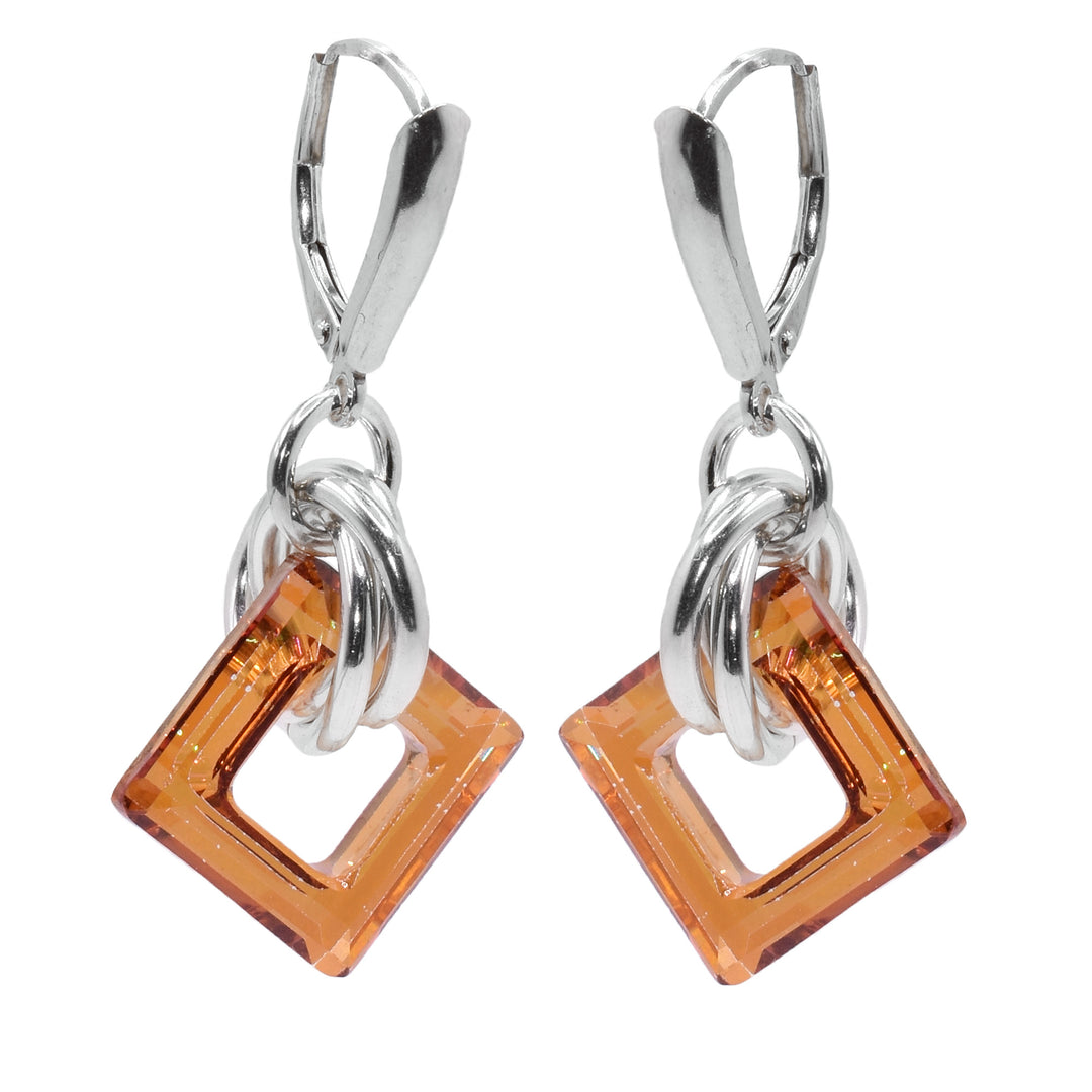 These small dangle hoop earrings have square shaped hoop hangs made from copper Swarovski crystals. The crystals have three sterling silver hoops linked through them and those hoops are linked through a smaller one attached to the hooks.