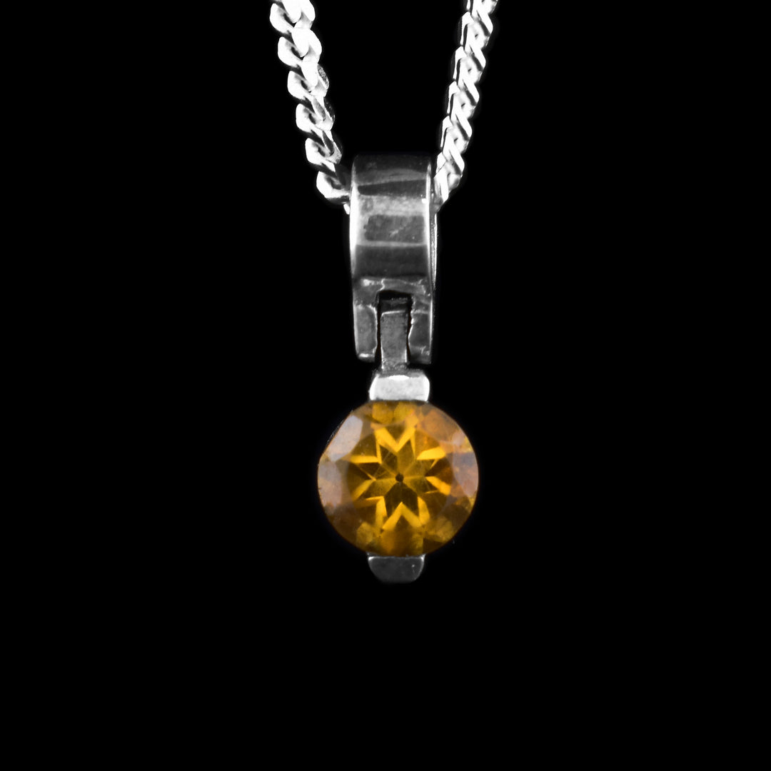 This orange citrine pendant has a sterling silver bail that attaches with a hinge to the orange citrine gem. There are two claws holding the gem at the top and the bottom.