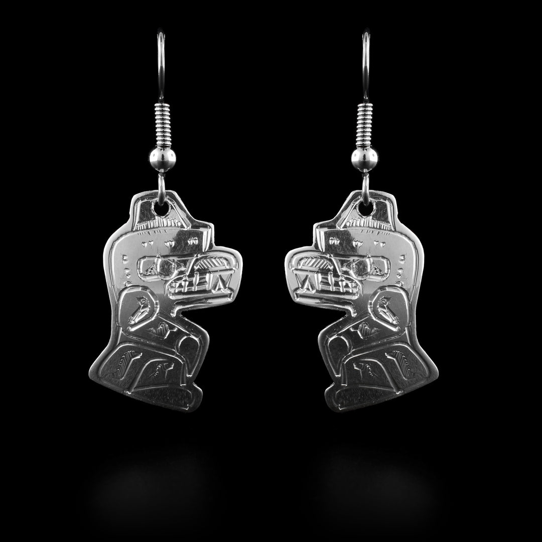 These Bear dangle earrings have Bear shaped hangs and are made from sterling silver. The Bear legend is also carved into the hangs with its head looking upwards and two of its paws on the ground and the others at its side. Its teeth are bared.