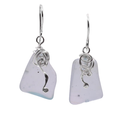 These dangling sea glass earrings have rough, rectangle shaped sea glass hangs. The glass is clear and foggy with sterling silver charms hanging from the hooks that represent sea kelp.
