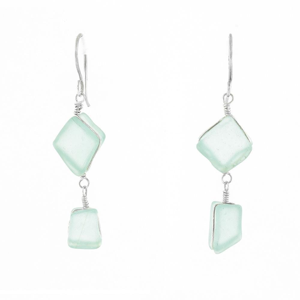 These sea glass dangle earrings have two, square shaped glass pieces hangings down from sterling silver hooks. The pieces of glass are hanging from each other so one is above the other.