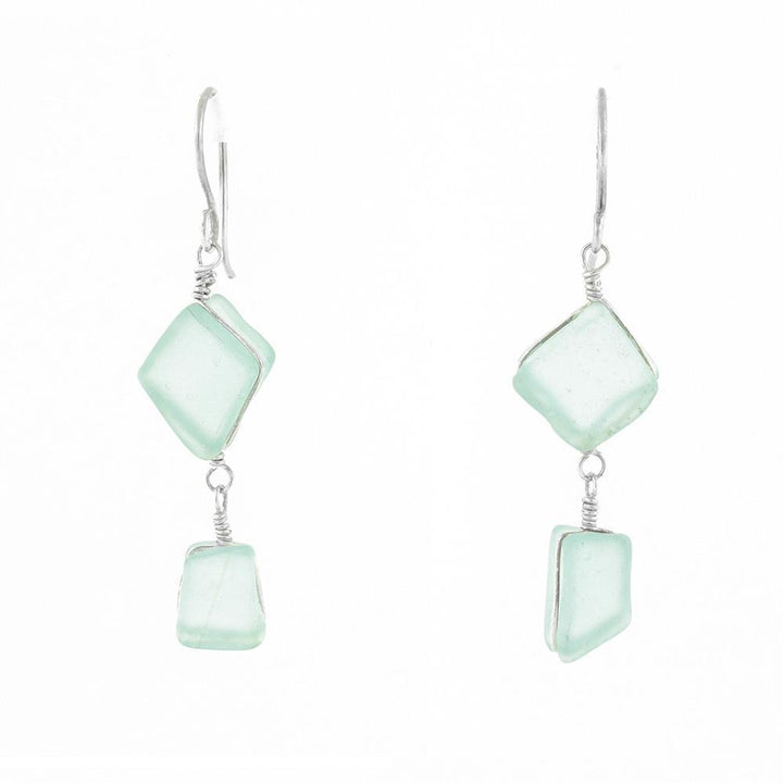 These sea glass dangle earrings have two, square shaped glass pieces hangings down from sterling silver hooks. The pieces of glass are hanging from each other so one is above the other.