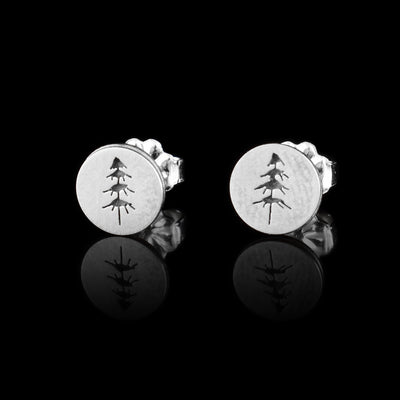 These tree earrings studs are made from sterling silver and have small, circle shaped faces. There is one simple tree designs made into the face of each stud. The trees have clumps of needles ascending to the top of there trunks.