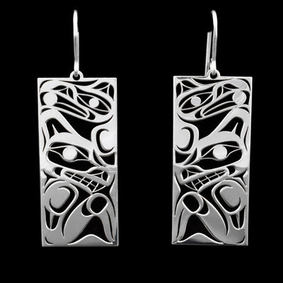 These wolf earrings are rectangular in shape and feature the head and body of a wolf carved into it with a raven on top.