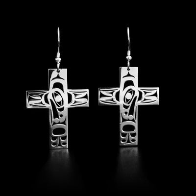 These sterling silver earrings hold the shape of a cross. The Raven holding the Sun is carved on the earrings. 