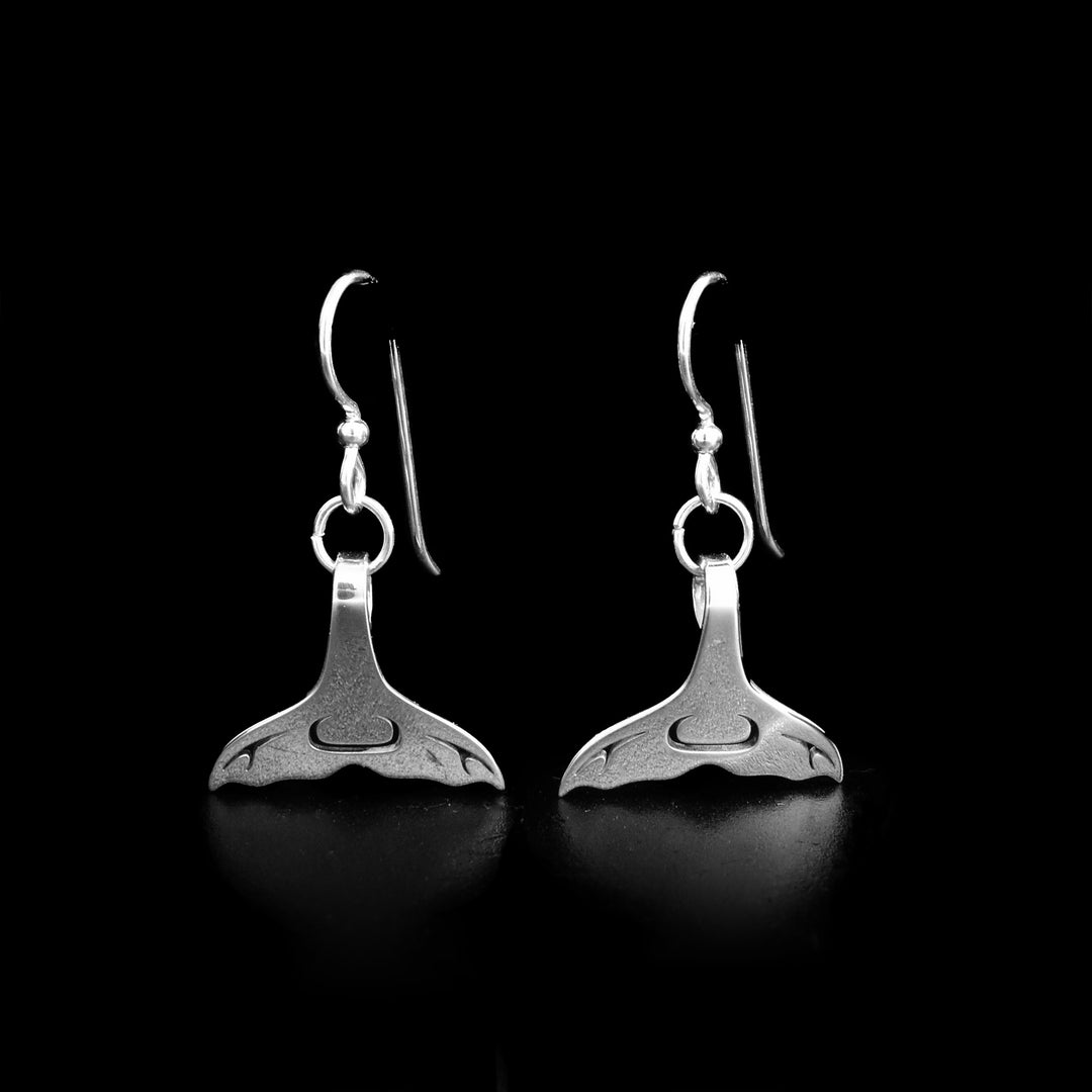 These sterling silver earrings were created by Tahltan artist Grant Pauls.  They hold the shape of a whale tail. The piece measures 0.75" x 1.5" including the hook. 