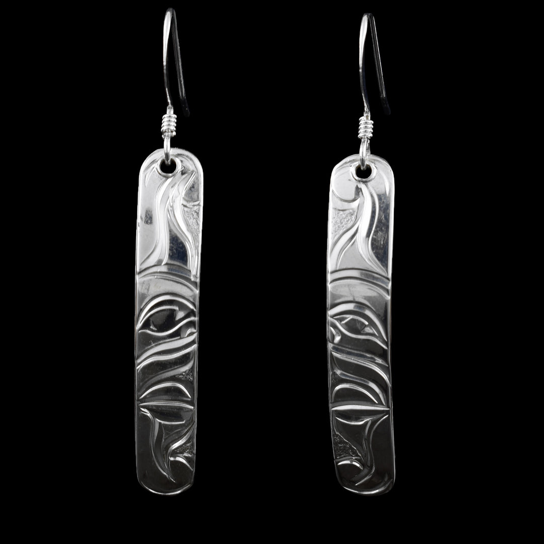 These sterling silver Moon earrings have long, thin and rectangle shaped hangs. There are wavy designs carved into the hangs depicting The Moon legend. There are wavy designs extending from the circle portion of the Moon.